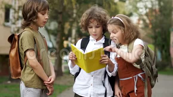 两个男孩和一个女孩青少年学校的孩子讨论一本关于放学路上的书女孩看到了大黄蜂和视频的预览图