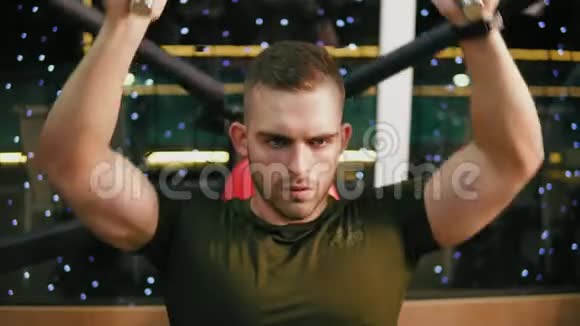 年轻的帅哥穿着军用t恤在健身房锻炼胸部肌肉和肩膀执行公务视频的预览图