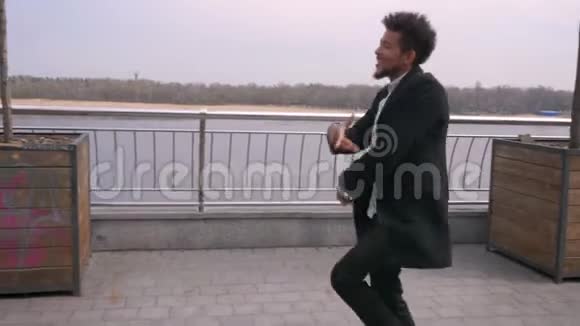 城市街道上年轻迷人的非裔美国男性快乐散步和跳舞的特写镜头视频的预览图