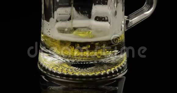将冰冷的金光啤酒倒入玻璃杯中手工啤酒制造气泡和泡沫视频的预览图