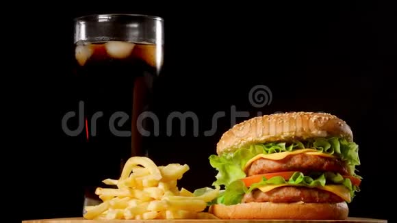 汉堡包配炸薯条和一杯冰可乐背景为黑色乡村风味视频的预览图