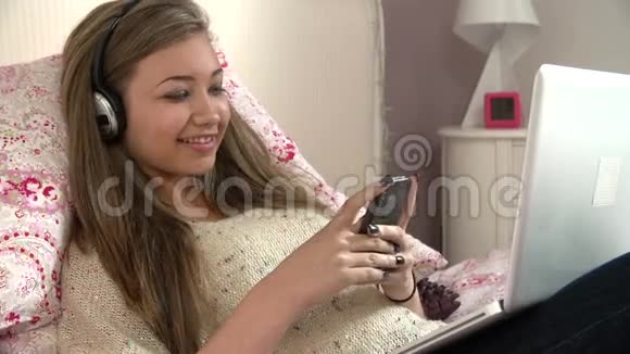 少女在发短信时用手提电脑躺在床上视频的预览图