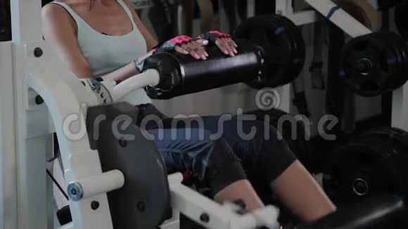 运动美女在模拟器腿部伸展上表演视频的预览图