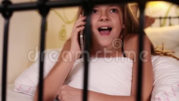 年轻女孩在床上用智能手机聊天视频的预览图