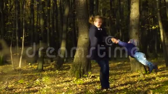 年轻的母亲和她的儿子在秋天公园玩4k视频的预览图