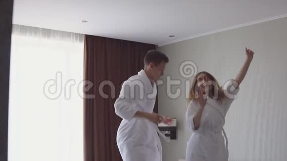 到达海滨公寓酒店后一对幸福的情侣在床上蹦蹦跳跳视频的预览图