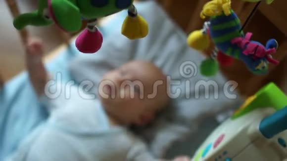 在婴儿床上移动玩具在躺在婴儿床上的孩子身上嘎嘎作响新生儿玩具教育玩具视频的预览图