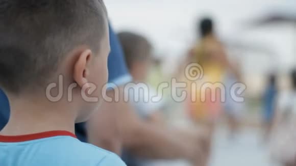小男孩看着一群人在户外跳舞视频的预览图