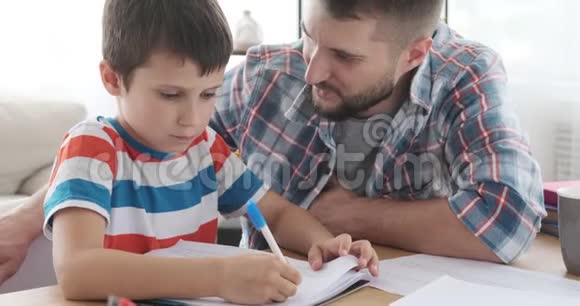 父亲和儿子在书上做作业视频的预览图