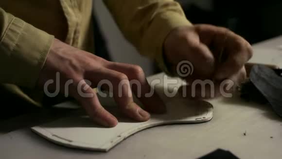 皮革工人在皮革毛坯中制作插槽上班时双手紧握鞋匠视频的预览图
