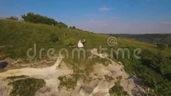 4K空中无人机镜头的夫妇在悬崖上奇妙的旅行概念视频的预览图