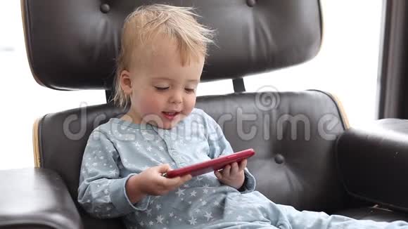 一个人坐在椅子上用智能手机的孩子视频的预览图