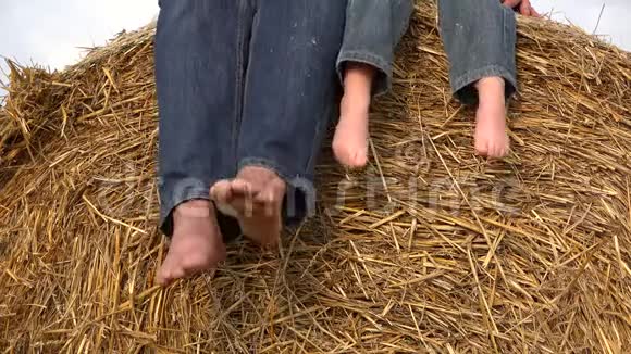 父母和孩子光着脚在干草堆上放松鞋底在玩耍视频的预览图