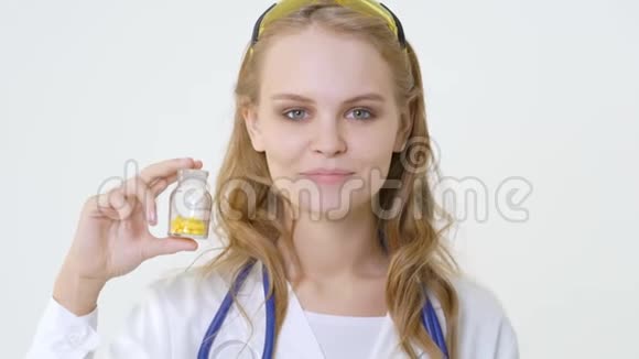 年轻的微笑医生带着一罐胶囊友好的女医生视频的预览图