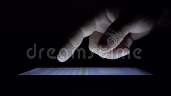 在黑夜里成人手指在平板上移动视频的预览图