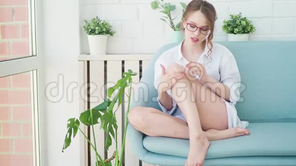 女孩把奶油放在腿上美丽的女人护肤视频的预览图