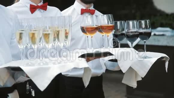 服务员用酒精饮料迎接客人托盘上有香槟红酒白酒视频的预览图