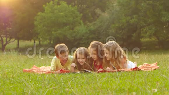 可爱的孩子们一起在草坪上看书夏天下午好视频的预览图