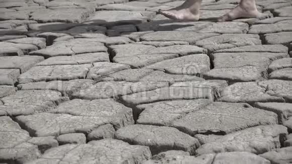 脚在干旱和开裂的土壤上行走裸费在干燥的地面上行走概念视频的预览图