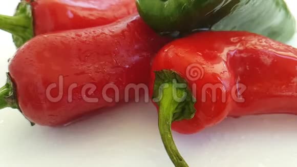 红椒和青椒冷湿喷雾慢动作背景烹饪视频的预览图