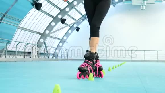 健身房里穿着溜冰鞋的女孩一个穿着溜冰鞋的运动女人的腿靠近在大厅里训练视频的预览图