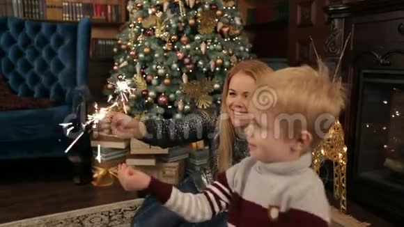 妈妈和儿子在圣诞树旁闪闪发光视频的预览图