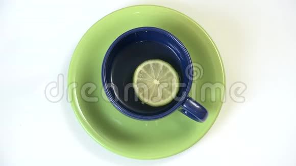 带茶的杯子和旋转柠檬片热饮视频的预览图