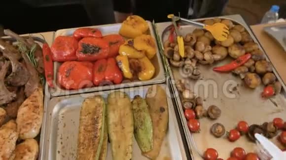 搭配蔬菜和烤肉瑞典餐桌厨师的手为客人端上一盘食物视频的预览图