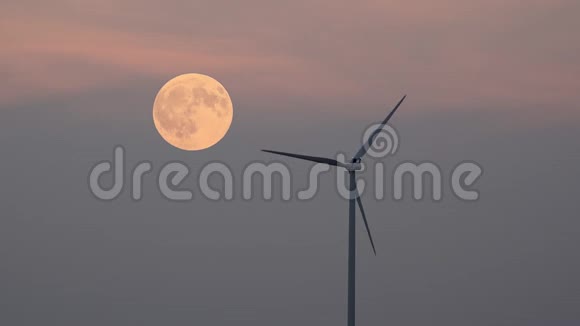 风车风力涡轮机旋转剪影和满月在红色夕阳的天空视频的预览图