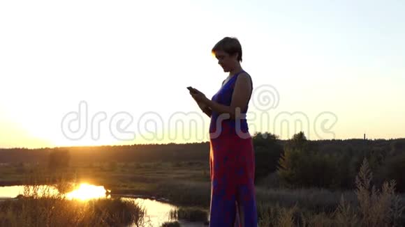 中年妇女站在湖边打电话视频的预览图