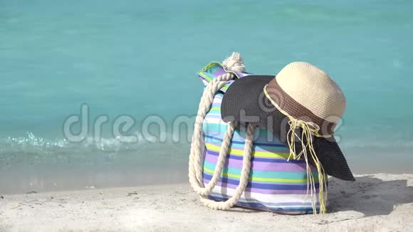 海滨有彩色的夏袋和帽子碧波荡漾美丽的海景视频的预览图