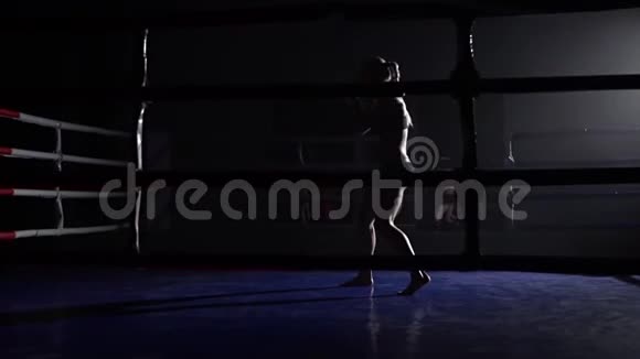 女运动员在黑暗的环中训练胜过她的腿剪影慢动作视频的预览图
