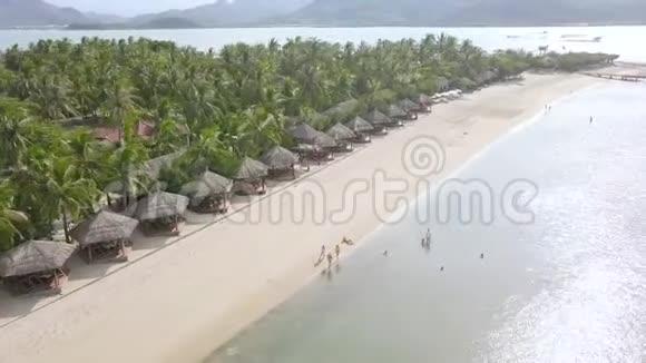 游客在豪华夏季海滩上的热带岛屿鸟瞰海滨浴场游客可以休息和游泳视频的预览图