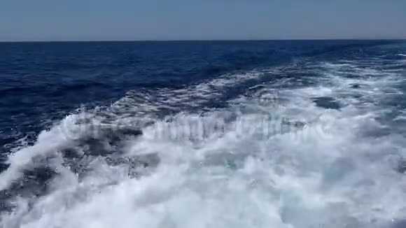 一艘快速漂浮的游艇后面的波浪和泡泡水视频的预览图