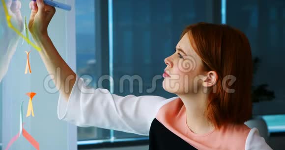 女高管在玻璃板粘纸条上写字视频的预览图