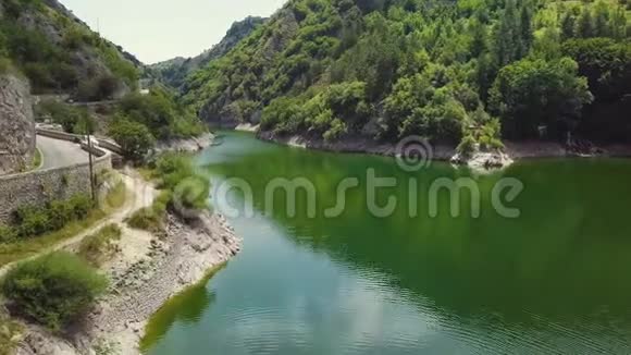 4k无人驾驶飞机拍摄的绿色山边人工湖旁大坝视频的预览图
