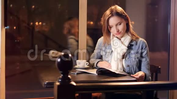 漂亮的女人在咖啡馆里读杂志4K视频的预览图
