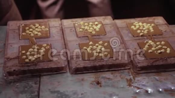 巧克力工厂制作巧克力的过程将液体巧克力倒入表格中加入坚果并冷却视频的预览图