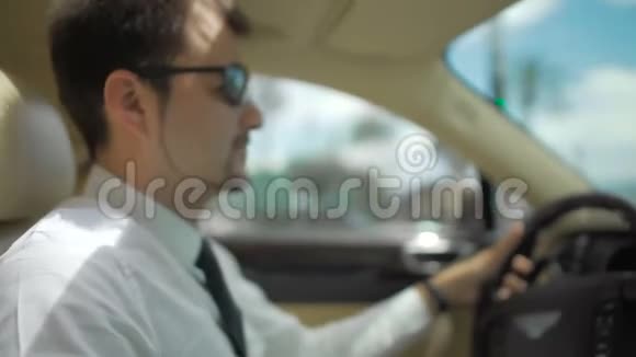 商人戴着太阳镜驾驶昂贵的汽车交通工具视频的预览图