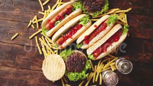 快餐品种汉堡和热狗放在生锈的木桌上视频的预览图