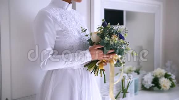 身着白色婚纱的年轻新娘手中捧着一束束美丽的鲜花视频的预览图