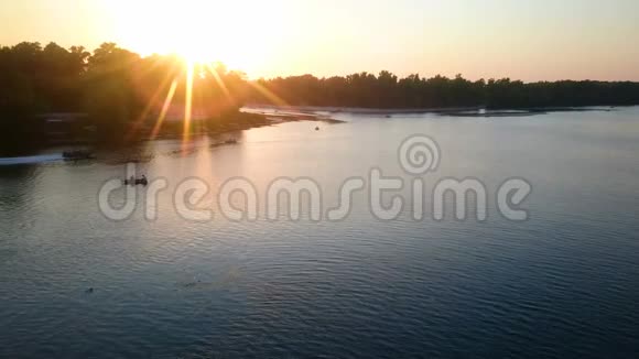 美丽的落日余晖映在河水中人们在船上尽情放松视频的预览图