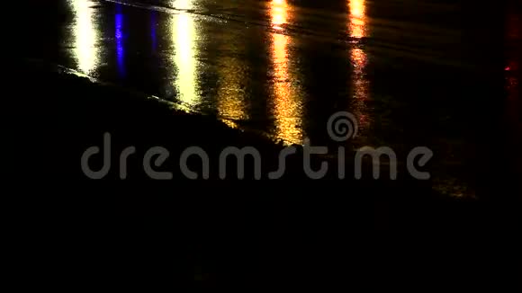 夜晚的雨滴穿过水坑水滴上的圆圈被路灯的光照亮自动视频的预览图