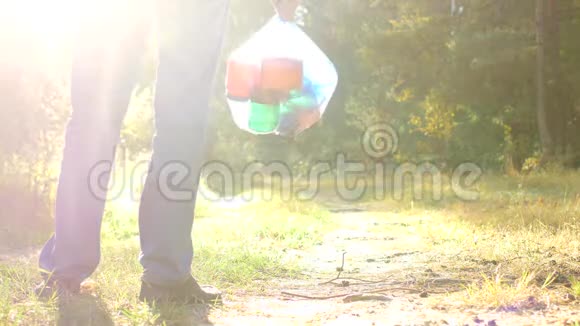 一个人站在森林空地上手里拿着一包垃圾一个垃圾收集器垃圾和自然很近视频的预览图