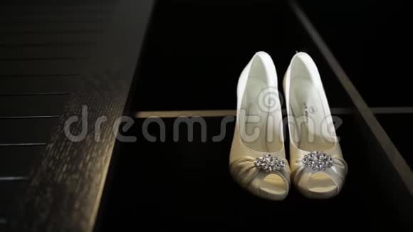 新娘婚礼漂亮的鞋子挂在一个黑色的柜子上豪华的鞋跟特写视频的预览图