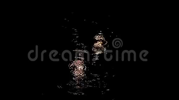 夜晚的雨滴穿过水坑水滴在水面上盘旋被路灯的灯光照亮汽车视频的预览图