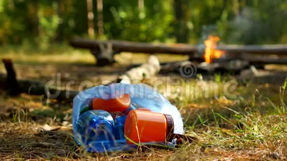 一袋塑料瓶的垃圾躺在草地上一场大火燃烧户外娱乐人们没有带走垃圾视频的预览图
