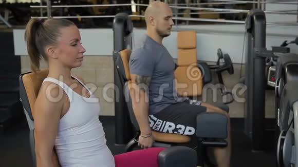 这对运动员们坐着用特殊的机器把他们分开训练他们的腿视频的预览图
