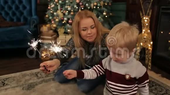 妈妈和儿子在圣诞树旁闪闪发光视频的预览图