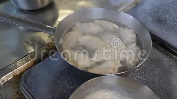 一位专业厨师在餐厅的厨房里用不锈钢盘子准备食物饺子的制作视频的预览图